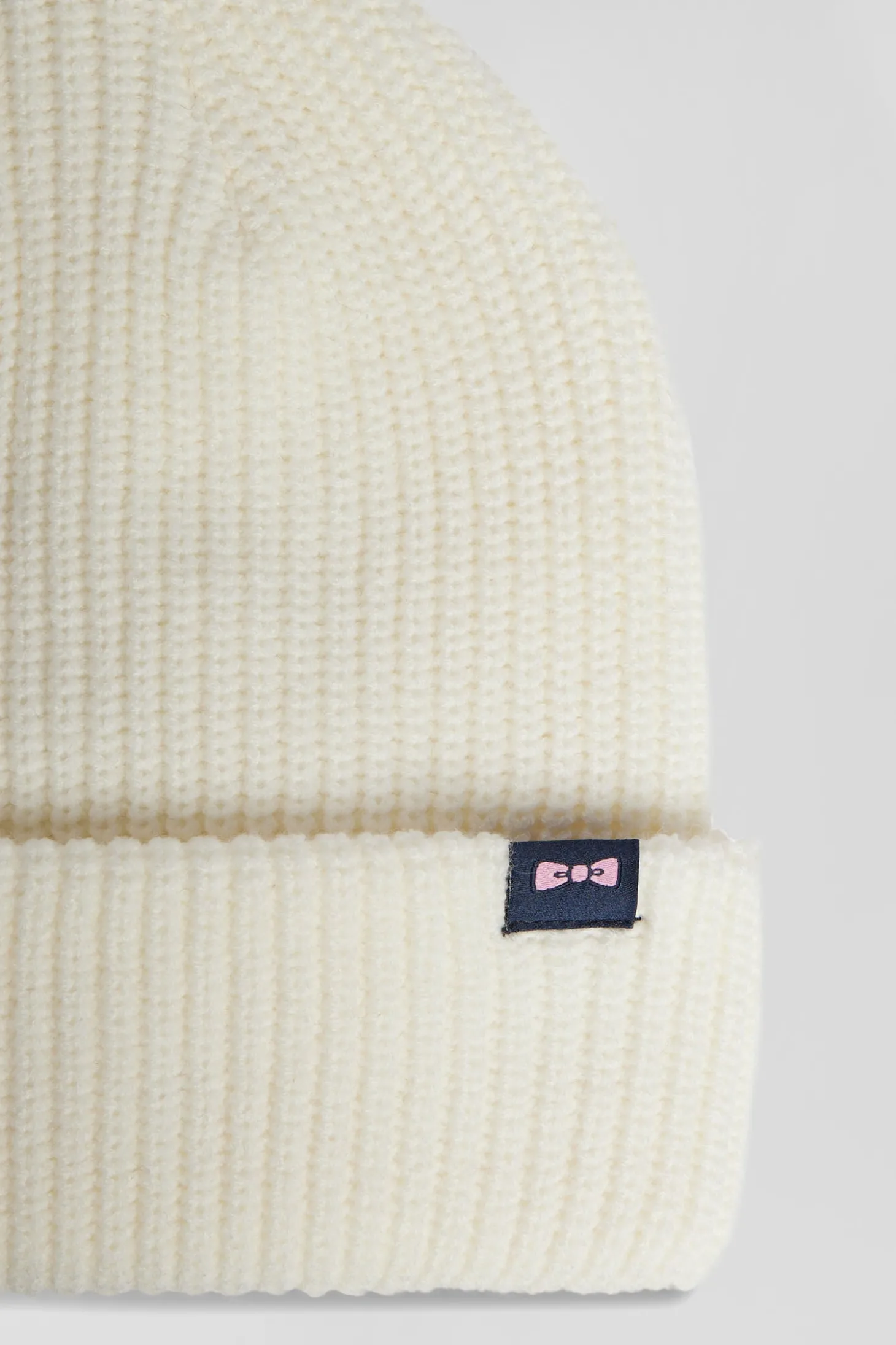 Ivory knitted beanie with bow tie embroidery