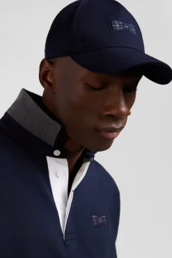 Navy blue cap with bow tie emblem