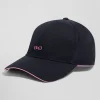 Navy blue cotton cap with bow tie badge and pink piping