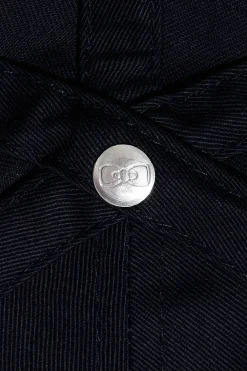 Navy blue cotton cap with bow tie badge and pink piping