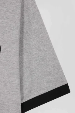 Oversize black short-sleeved cotton piqué polo shirt with tricolor details